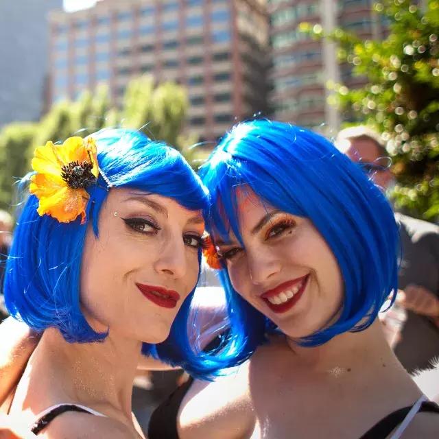 两个戴着蓝色假发的女人参加了贝博体彩app的骄傲游行.